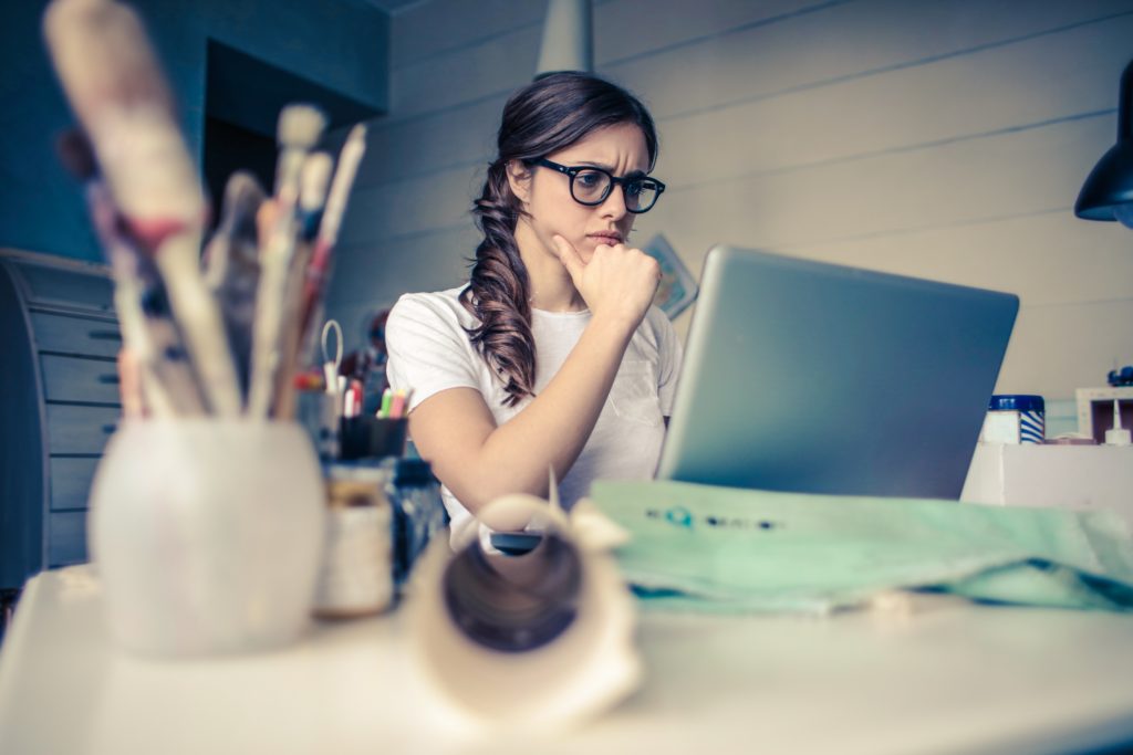 Woman in glasses struggling to focus at her desk.
