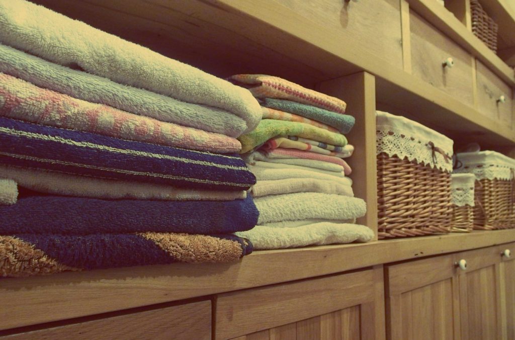 A clean closet with baskets and towels.